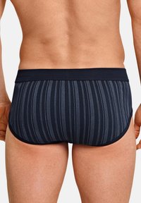 Shorts de bain navy avec des rayures verticales bleu clair, taille élastique, design ajusté et texture lisse, adaptés aux activités aquatiques.