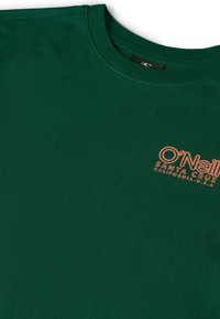 Tamsiai žalia medvilninė marškinėliai su apvalia apykakle ir trumpomis rankovėmis. Priekyje yra oranžinė O'Neill logo su "Santa Cruz" tekstu.