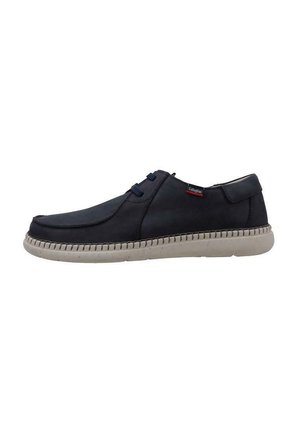 Zapatos de cuero azul marino con punta redondeada, suela de goma gris y detalles cosidos. Presentan dos ojales para los cordones y un acento de marca.