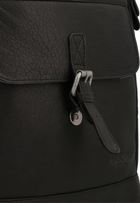 Zaino in pelle nera con finitura testurizzata, dotato di chiusura a patta, hardware in tono argento e una marcatura in rilievo laterale.