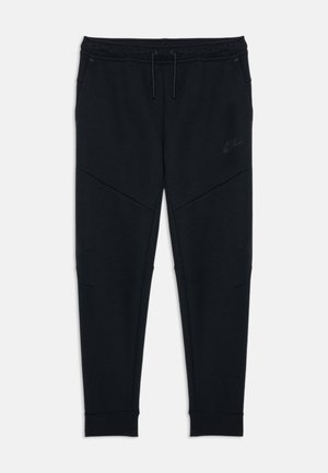 Sorte tapered Nike joggingbukser med snor i taljen og sidelommer, med en diskret Nike-logo på venstre lår.