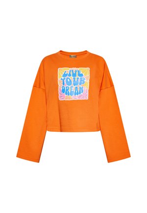 Oranssi lyhythihainen pitkähihaiseen paita, jossa on värikäs "ELÄ UNELMASI" -grafiikkaa kukka-akseleiden ympäröimänä. Pehmeä kangas, jossa on rento istuvuus.