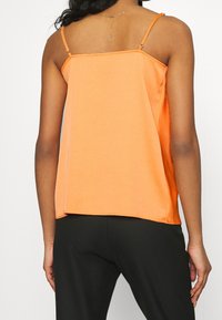 Orange ärmlös topp med lös passform, fyrkantig halsringning och justerbara axelband. Mjuk tyg med en slät textur och minimalistisk design.