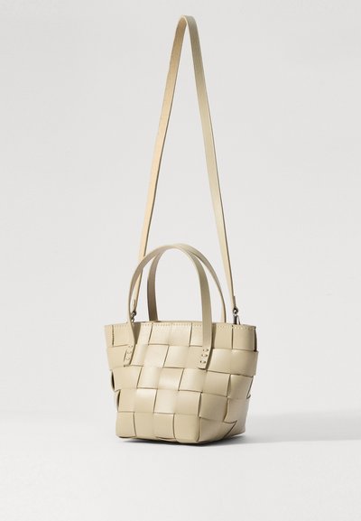 Beige kudottu nahkainen olkalaukku, jossa on kaksi lyhyttä kahvaa ja yksi pitkä hihna. Siinä on nelikulmainen kuvio ja jämäkkä muoto. Elegantti pinta ja viimeistely.