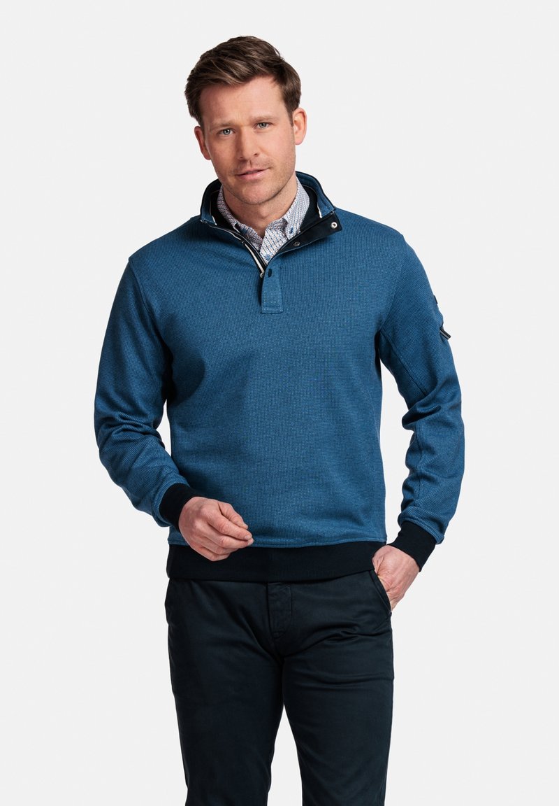 Blauwe pullover sweatshirt met een kwart ritssluiting, ribgebreide kraag en manchetten. Geweven stof, accent op een zwarte kraag en een patch op de mouw.