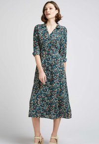 Robe portefeuille florale en bleu sarcelle, avec un col, des manches retroussées et une jupe mi-longue. Détail d'un motif floral multicolore.