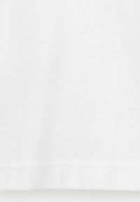 Material alb cu o textură subtilă și o margine cusută la partea inferioară.