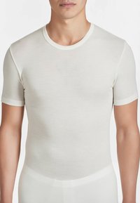 T-shirt a maniche corte, con collo a girocollo, di colore avorio, realizzato in tessuto morbido e leggero con una texture liscia e un design aderente.