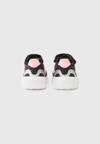 Chaussures de sport noires et roses avec une tige texturée, un détail de talon contrastant et une semelle extérieure blanche. Design léger adapté à une utilisation active.