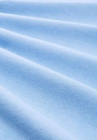 Lichtblauwe stof met een gladde textuur, met horizontale plooien en een consistent weefpatroon door de hele stof.