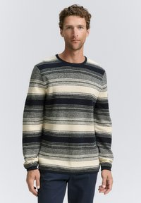 Pullover trui in cream, marineblauw en grijs met horizontaal gestreept patroon. Gebreide textuur en ronde halsontwerp, met geribbelde manchetten en onderrand.