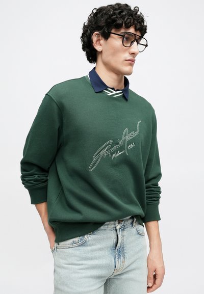 Πράσινο φούτερ με σκούρο μπλε γιακά, διακοσμημέν ο με λευκή κεντητή γραφή και ρίγες στον γιακά. Υφή υφάσματος, άνετη εφαρμογή.