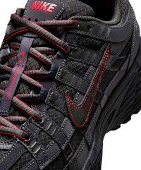 Baskets Nike noires et rouges en tissu mesh, logo swoosh rouge brodé et lacets détaillés étiquetés "90s NURSERY SERIES."