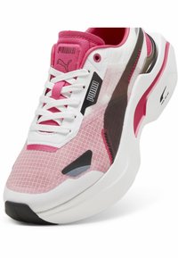 Lekkie buty sportowe z różowo-białą siateczką, czarnymi i różowymi akcentami, wyściełanym kołnierzem oraz teksturowaną podeszwą.