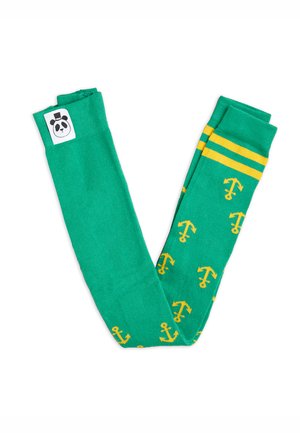 Calcetines verdes con patrones de anclas amarillas y dos franjas amarillas en la parte superior. Presenta un logotipo de panda en blanco y negro en un lado.