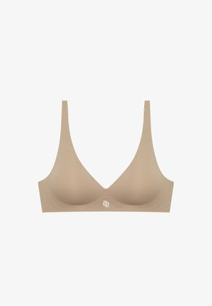 Beige soft fabric bra with a seamless design, wide straps, and a subtle logo at the center. Lightly molded cups for shape.