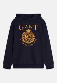 Hoodie marine en coton, arborant un grand logo jaune avec un design de couronne et de laurier. Manches longues et poche kangourou à l'avant.