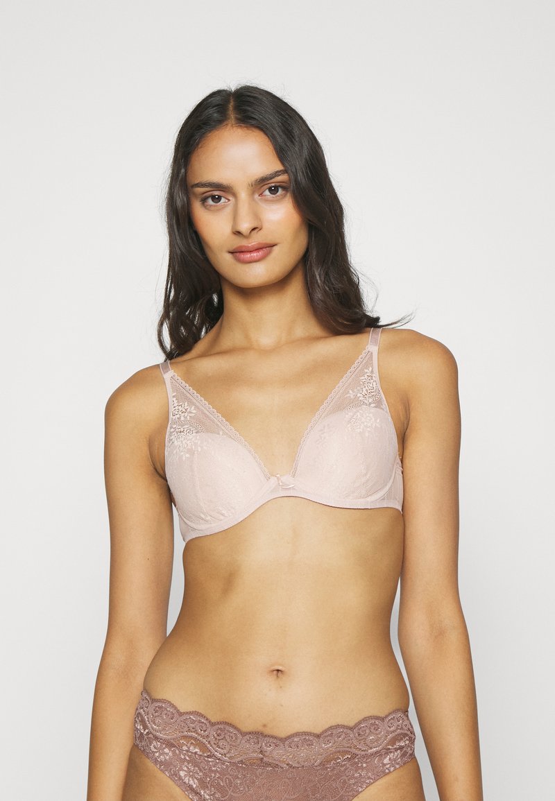 Helle rosa Unterwäsche mit Spitzendetails, weichem Finish und Unterstützung durch Bügel. Verzierte Akzente befinden sich in der Mitte und an den Trägern.