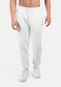 Pantalones de chándal blancos para hombre, hechos de una mezcla de algodón, con una textura suave, cinturilla elástica con cordón y bolsillos laterales.