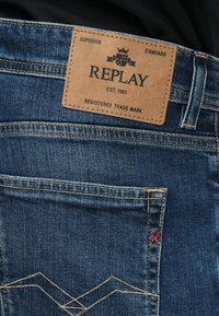 Πίσω τσέπη τζιν με ετικέτα Replay από μπεζ δέρμα ραμμένη από πάνω και διακοσμητική ραφή στην τσέπη.