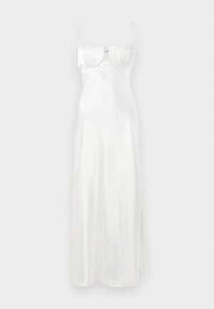 Balta satino maxi suknelė su prigludusia liemene, švelniu širdies formos iškirpimu, reguliuojamomis plonomis petnešėlėmis ir šonu įpjova. Lygi, blizganti tekstūra.