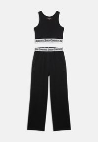 Čierny bezrukávový crop top a široké nohavice s bielymi elastickými pásmi s textom "Juicy Couture" na páse a leme.
