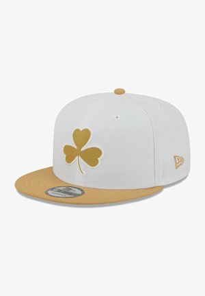Weiße Kappe mit goldenem Kleeblatt-Logo auf der Vorderseite, kontrastierendem goldfarbenem Schirm, strukturierter Form und verstellbarem Snapback-Verschluss hinten.