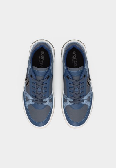 Ζευγάρι μπλε και γκρι αθλητικά παπούτσια με κορδόνια και λευκές σόλες, με υφές από δίχτυ και δέρμα και το όνομα της μάρκας στο εσωτερικό.