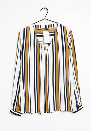 Langærmet bluse med lodrette hvide, sorte og sennepsstriber, v-udskæring, hængende på en sort bøjle med en hvid prisseddel.