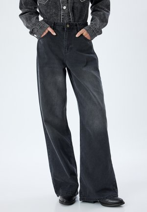 Pantaloni in denim grigio scuro a gamba larga con vita alta, tasche laterali e chiusura a bottone. Il tessuto ha una texture leggermente sbiadita.