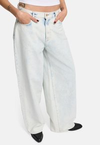 Hellblaue, weit geschnittene Jeans aus Denim mit einem verwaschenen Finish. Mit zwei vorderen Taschen und einem klassischen Knopfverschluss.