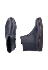 Stivali alla caviglia in pelle navy con cerniera laterale, punta rotonda e suola in gomma testurizzata. Accenti marroni sulla suola e dettaglio del logo sul lato.