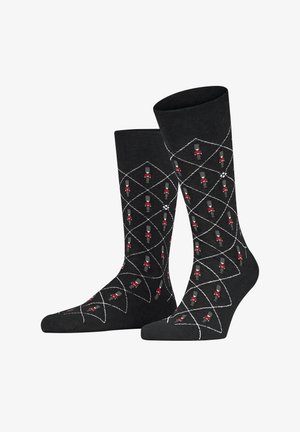 Schwarze Socken mit einem Diamantmuster, das rote und graue Spielzeugsoldaten zeigt. Hergestellt aus weichem Material mit glatter Textur und mit sauberen Abschlüssen.