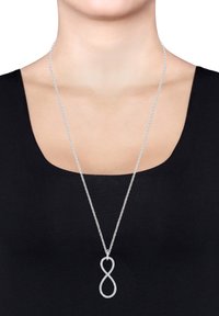 Sølv kædellar med en uendelighedsformet vedhæng prydet med små glitrende sten. Glat overflade, minimalistisk design.