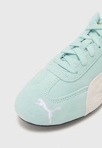 Baskets en suède vert menthe avec un logo Puma blanc. Présente un design classique à lacets et des détails texturés sur le côté.