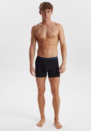 Sorte boxershorts med tætsiddende design, prydet med en kontrastfarvet blå talje. Materialet virker glat og elastisk.