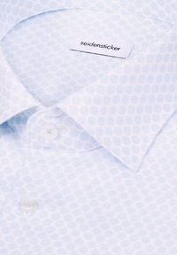 Chemise blanche à motif géométrique subtil, col boutonné, avec l'étiquette de marque "seidensticker" visible à l'intérieur du col.