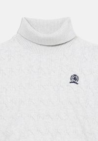 Ljusgrå polotröja med ribbade detaljer och strukturerad kabelstickning. Inkluderar en liten marinblå logotyp på övre vänstra sidan.