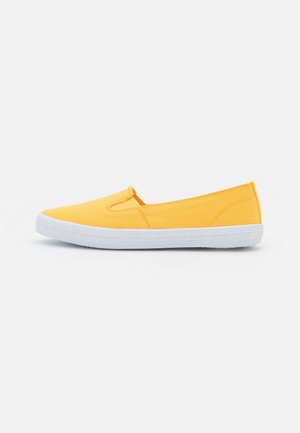 Chaussure slip-on en toile jaune avec une semelle en caoutchouc blanche. Présente un bout arrondi et des panneaux élastiques sur les côtés pour un accès facile. Design plat sans motifs.