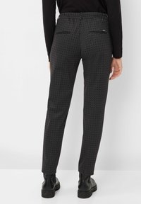 Zwarte patroongedrukte broeken met een slim fit, voorzien van een textuurstof, achterzakken en een licht elastische tailleband. Draag met zwarte laarzen.