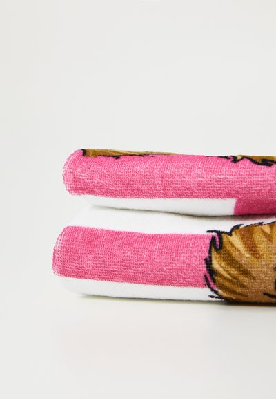 Rožinė ir balta rankšluostis su tekstūruotu paviršiumi. Viename krašte yra atspausdintas pieštuko personažo dizainas.