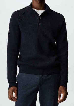 Maglione a coste blu navy con mezza pattina dei bottoni, maniche lunghe e vestibilità rilassata, abbinato a pantaloni scozzesi texture.