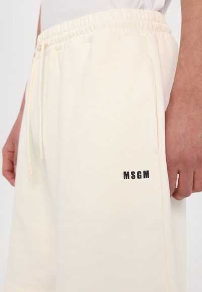 Kerman neulotut shortsit, joissa on joustava vyötärö, sivutaskut ja musta MSGM-logo vasemmassa alakulmassa. Pehmeä rakenne ja rento malli.