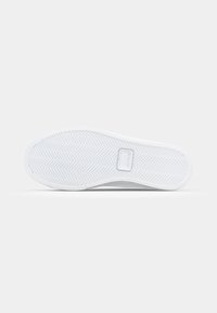 Talpa de pantof din cauciuc alb cu model herringbone și logo. Textură netedă și formă rotunjită, concepută pentru tracțiune și durabilitate.
