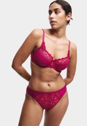 Fuchsia kant lingerie set met een gepadded beha met golvende randen en stippen details, gecombineerd met bijpassende slips met bloemenaccenten.