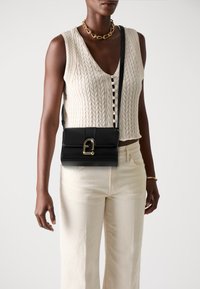 Borsa a tracolla in pelle nera con fibbia dorata, forma rettangolare, texture liscia e una sottile tracolla regolabile.