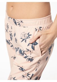 Lichtroze joggingsbroek met een marineblauw bloemenpatroon, elastische tailleband, zijzakken en een zachte, structuurstof.