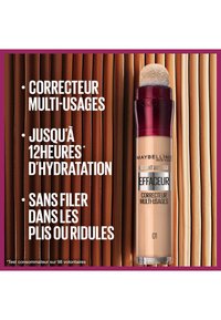 Correcteur antioxydant Instant Anti-Age de Maybelline dans un conteneur transparent avec un capuchon applicateur en éponge arrondi, présentant un liquide beige marqué "01."