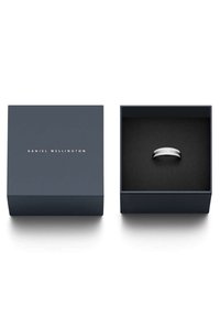 Hopeasormus tummansinisessä laatikossa, jossa on kultainen "DANIEL WELLINGTON" -logo kannessa ja musta pehmustettu sisustus.