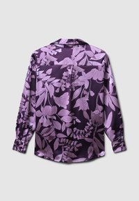 Vista posteriore di una blusa viola con un tessuto lucido con un motivo floreale in tonalità più chiare, maniche lunghe e un design di colletto classico.